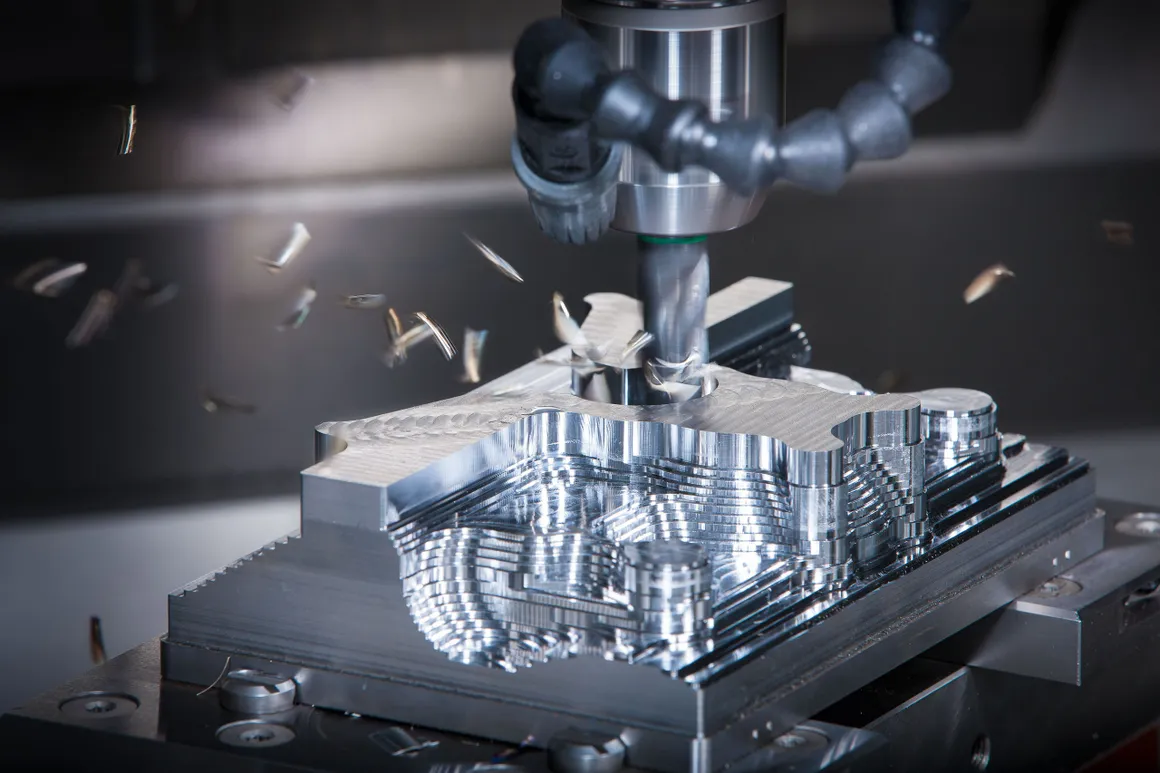 CNC milling machine cutting metal block