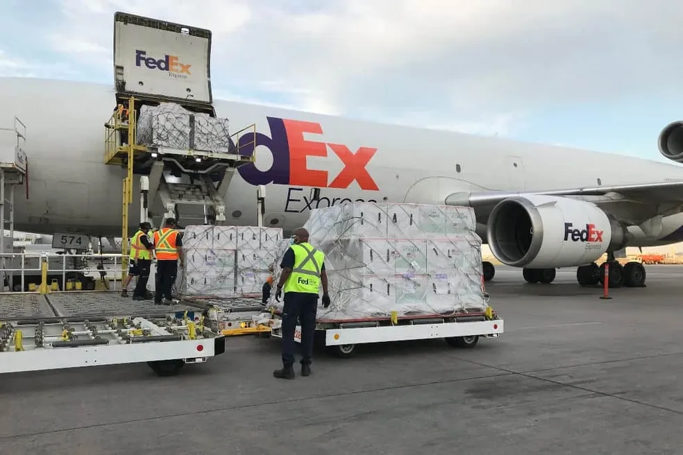 Workers loading FedEx cargo onto airplane